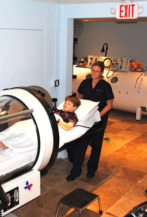 Healthcare worker helping a patient into a hyperbaric chamber