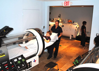 Healthcare worker helping a patient into a hyperbaric chamber