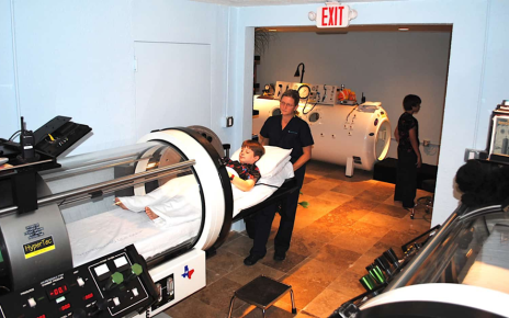 Healthcare worker helping a patient into a hyperbaric chamber