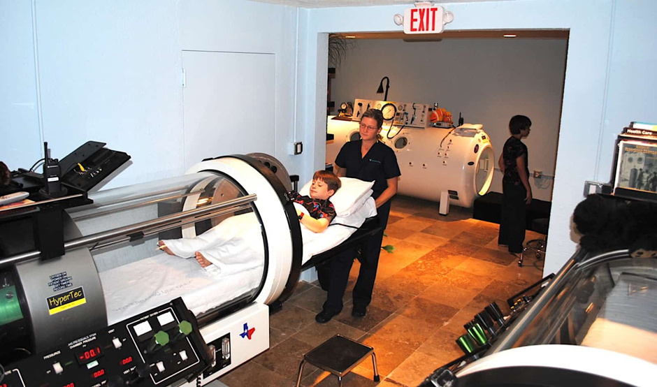 Healthcare worker helping a patient into a hyperbaric chamber